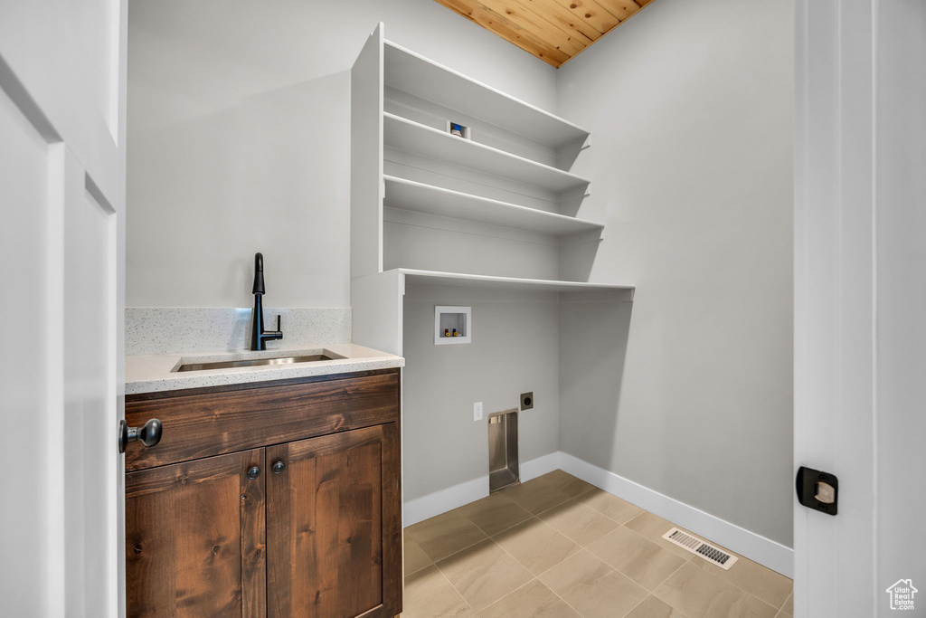 Laundry room featuring washer hookup, a sink, baseboards, electric dryer hookup, and visible vents