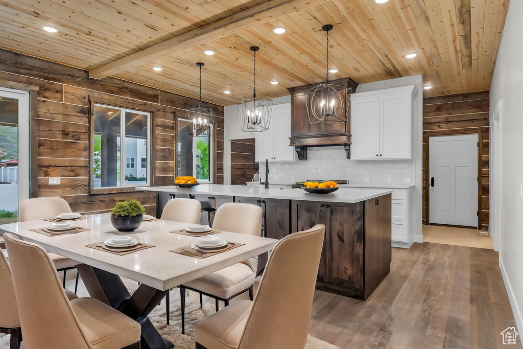 Kitchen featuring a notable chandelier, light wood-style floors, an island with sink, recessed lighting, and wooden ceiling