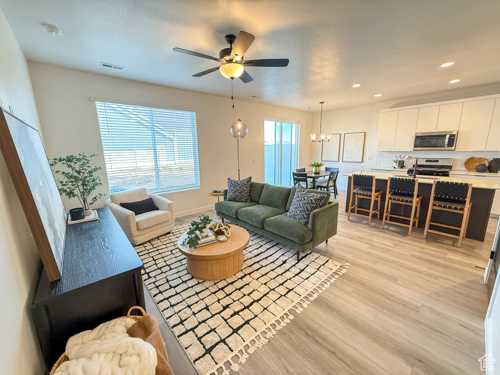 Living room with recessed lighting, visible vents, a wealth of natural light, and light wood-type flooring