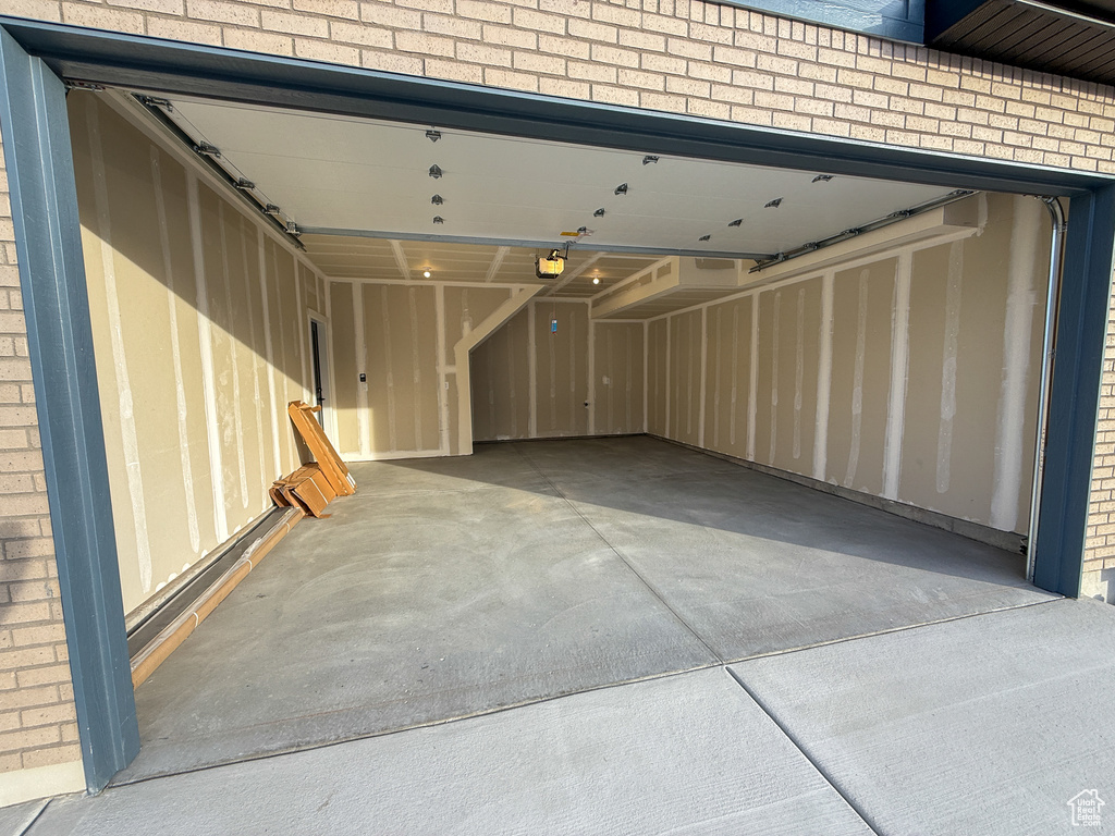 Garage featuring a garage door opener and concrete driveway