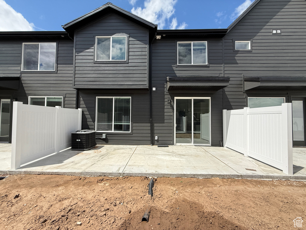 Back of house with a patio, central AC unit, and fence