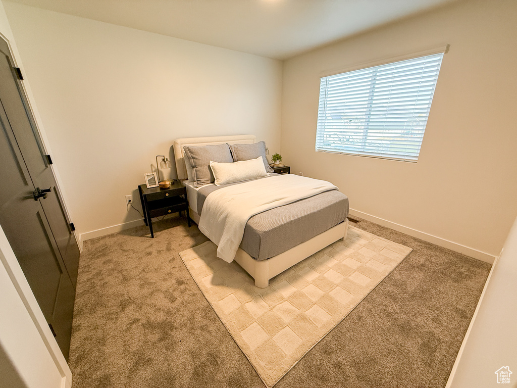Bedroom with baseboards and light colored carpet