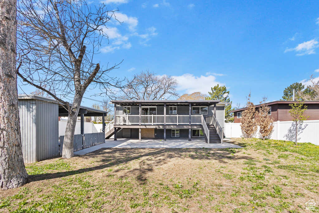 Back of property featuring a patio, a fenced backyard, an outdoor structure, and stairs