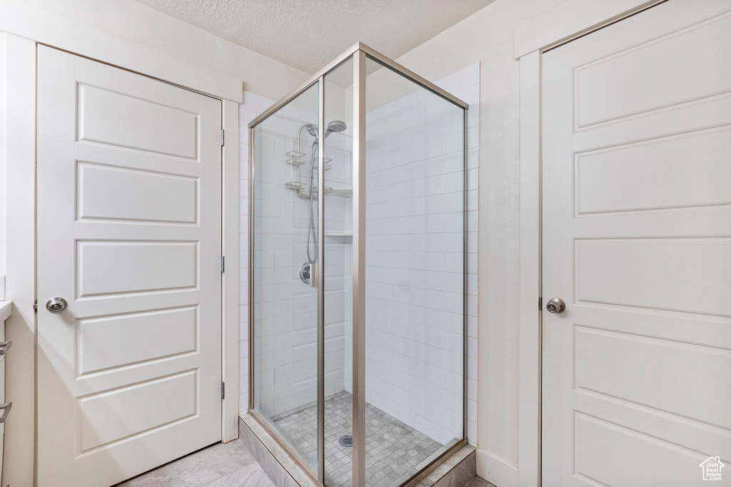 Bathroom with a stall shower, vanity, and a textured ceiling
