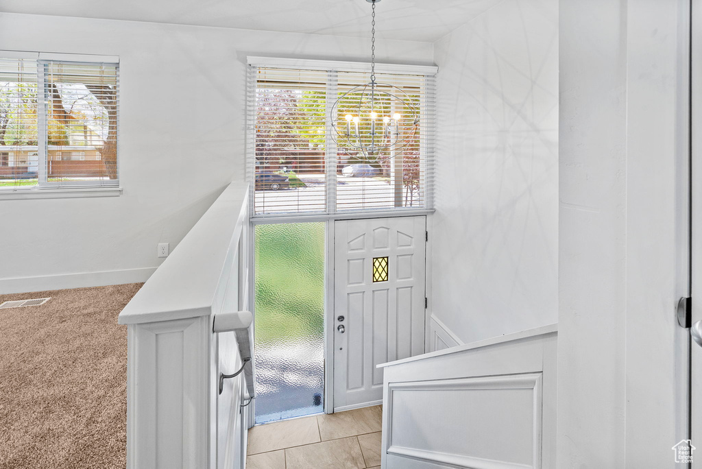 Foyer entrance with an inviting chandelier, a healthy amount of sunlight, and visible vents