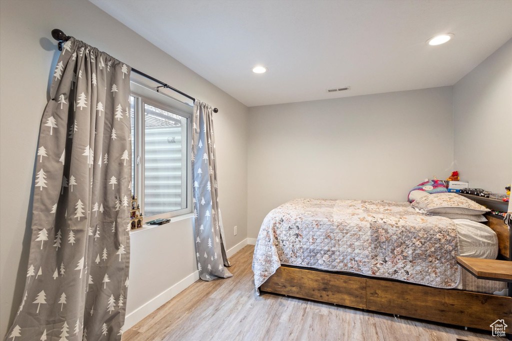 Bedroom with baseboards, recessed lighting, wood finished floors, and visible vents