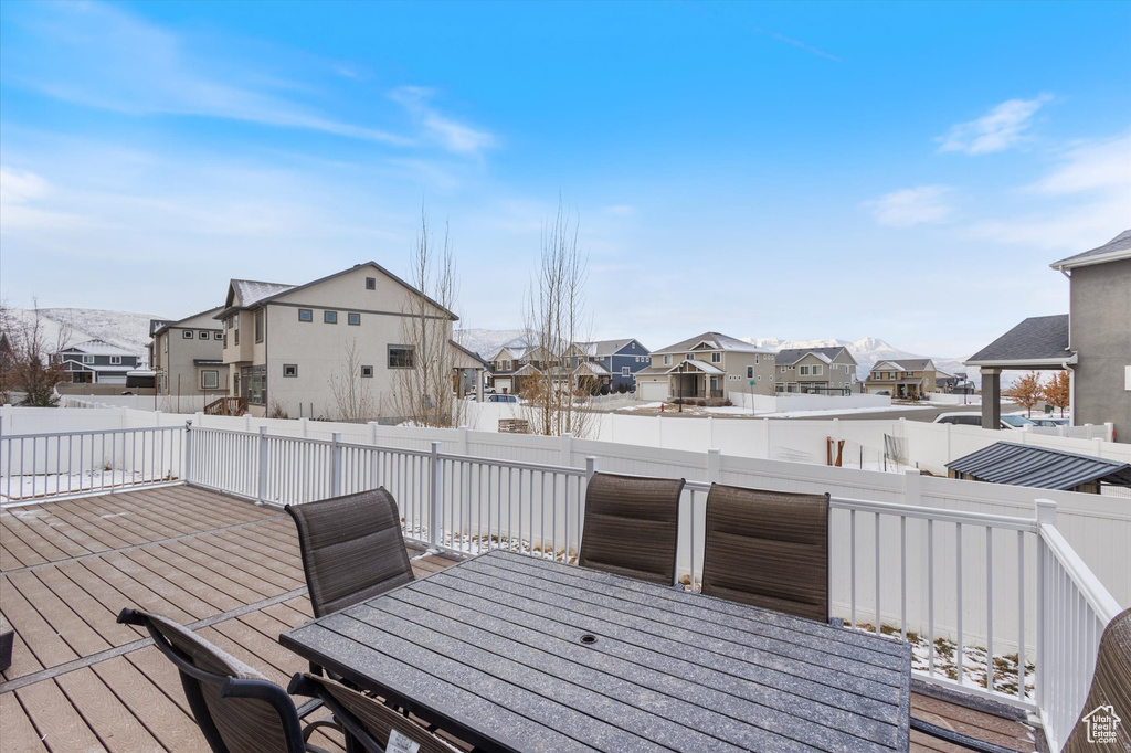 Wooden terrace with a residential view, outdoor dining space, and a fenced backyard