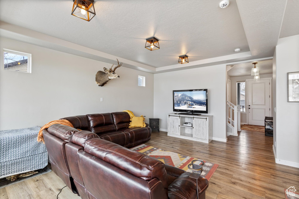Living area featuring baseboards, light wood-type flooring, and a wealth of natural light