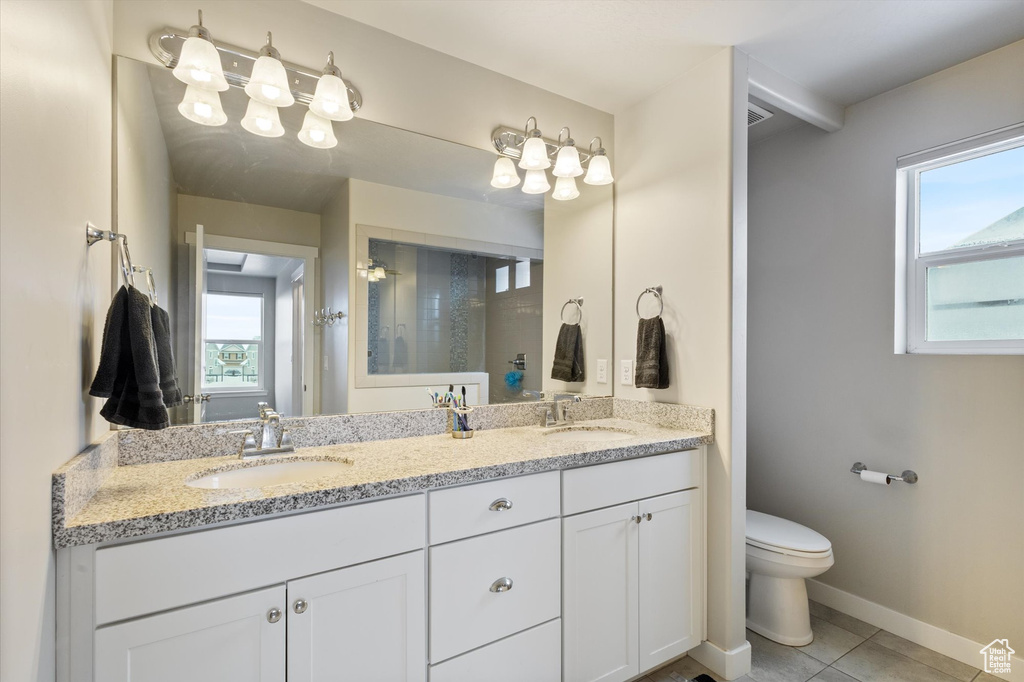 Bathroom featuring a sink, plenty of natural light, and toilet