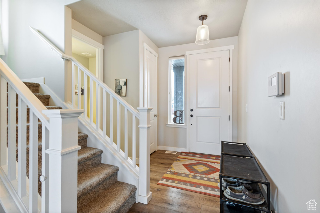 Entryway featuring stairs and wood finished floors