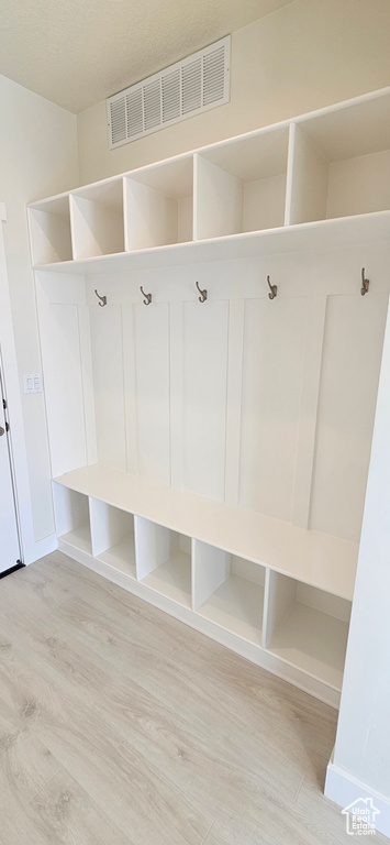 Mudroom with light wood-style flooring and baseboards