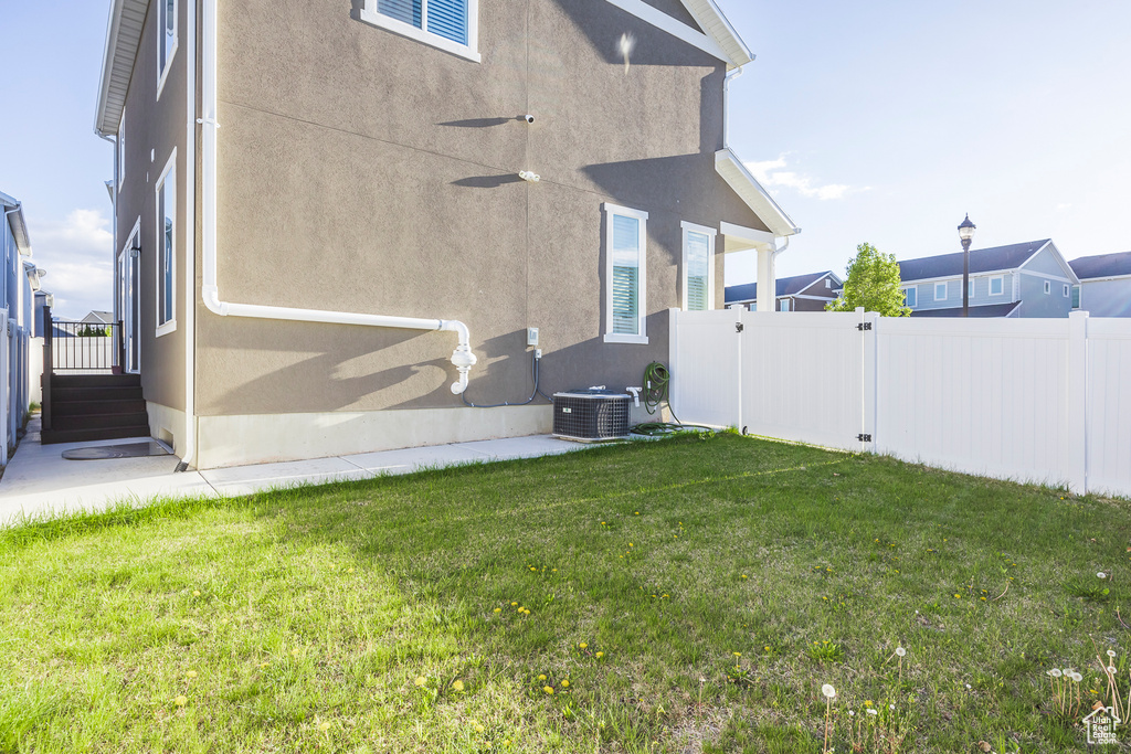 Exterior space featuring ceiling fan, cooling unit, a gate, and a fenced backyard