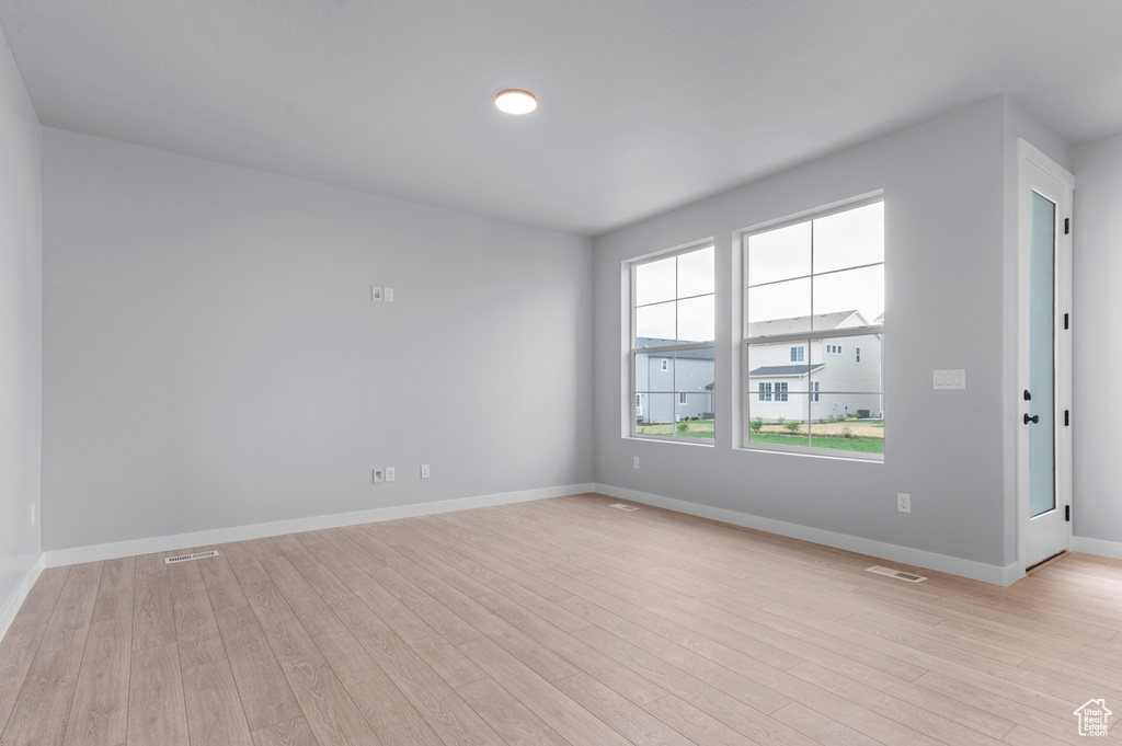 Spare room featuring light wood-type flooring and baseboards