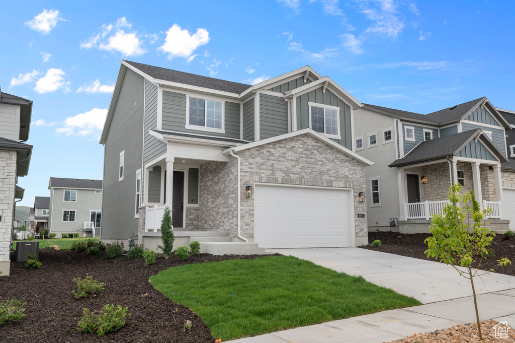 View of front of home featuring a porch, concrete driveway, board and batten siding, a garage, and central AC