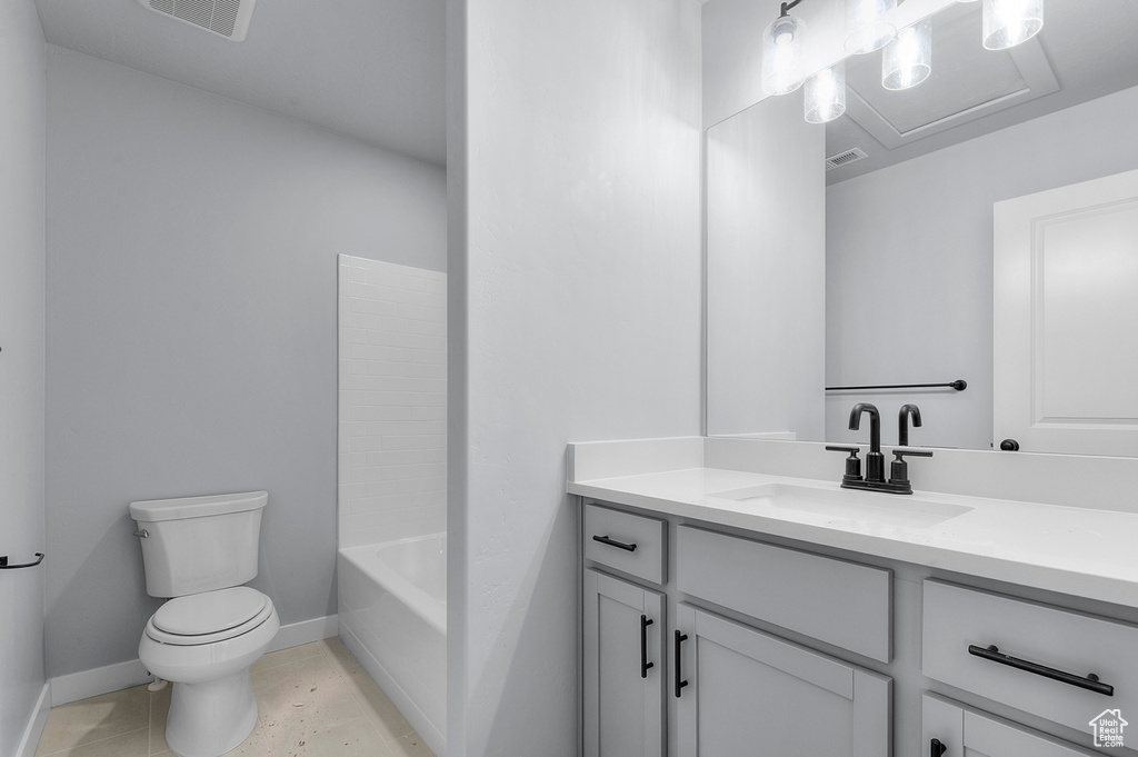 Bathroom featuring toilet, vanity, and baseboards