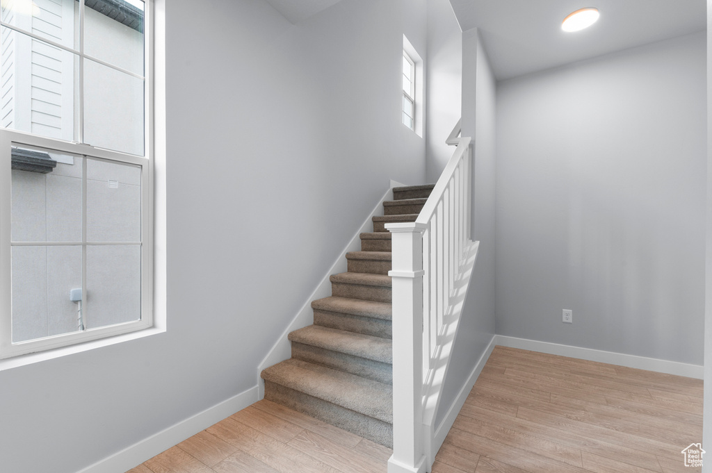 Staircase with wood finished floors and baseboards