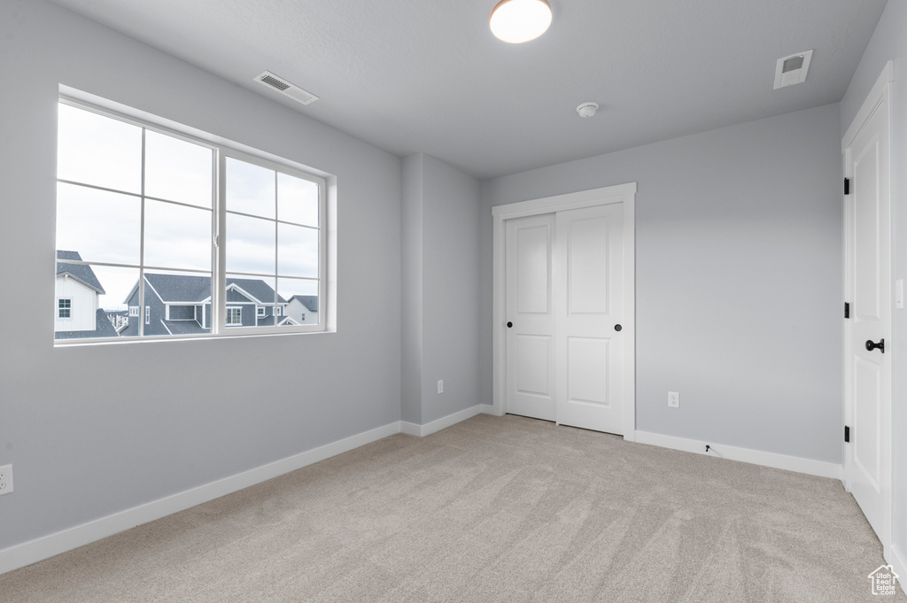Unfurnished bedroom with carpet floors and baseboards