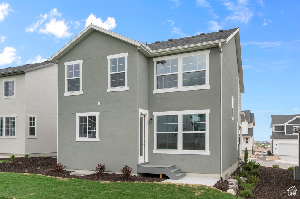 Rear view of house featuring stucco siding and a yard