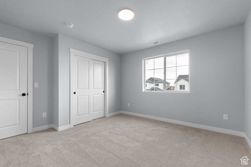 Unfurnished bedroom with carpet, baseboards, and a closet
