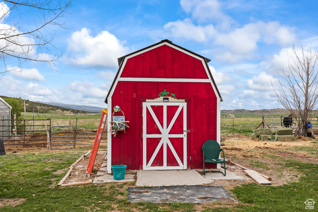 View of shed with fence and a rural view
