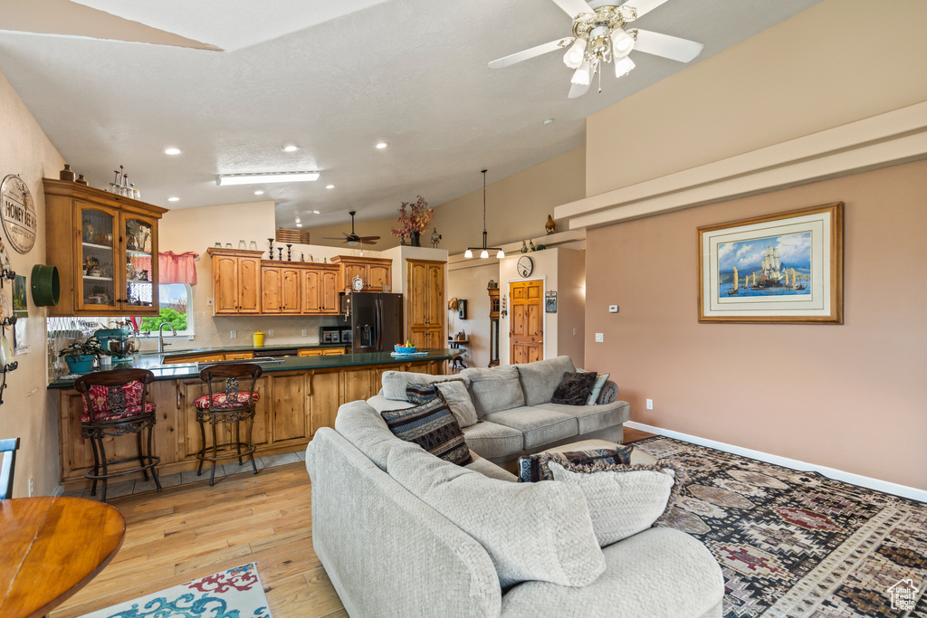 Living area featuring recessed lighting, ceiling fan, vaulted ceiling, and light wood-type flooring