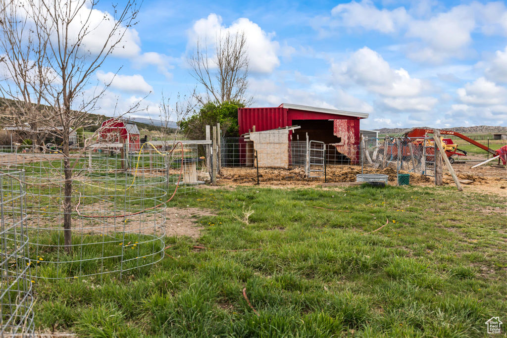 View of yard with exterior structure, fence, and an outdoor structure