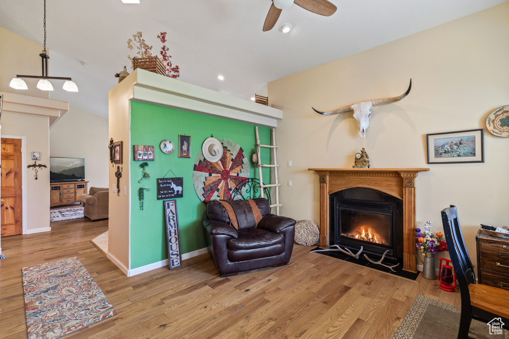 Sitting room with wood finished floors, baseboards, ceiling fan, recessed lighting, and a fireplace with flush hearth