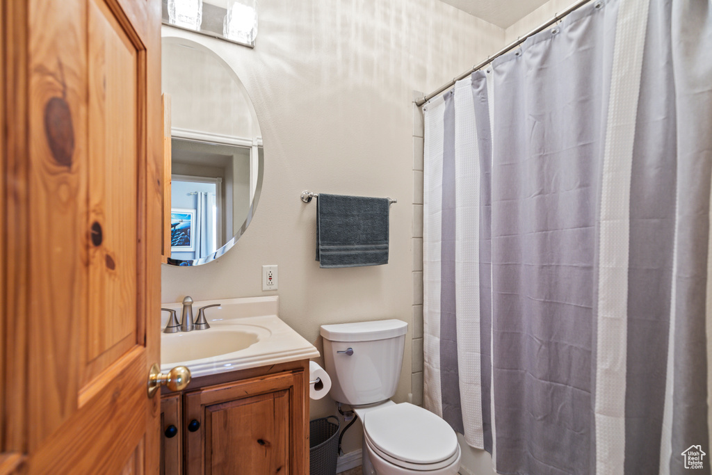 Bathroom featuring vanity, toilet, and a shower with curtain