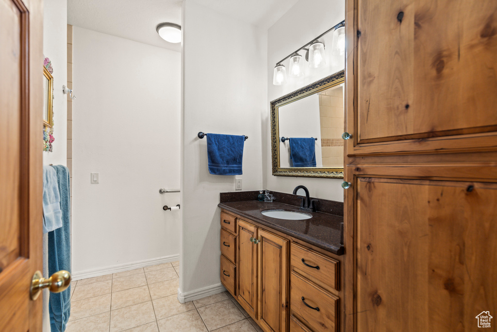 Bathroom with vanity, baseboards, and tile patterned floors