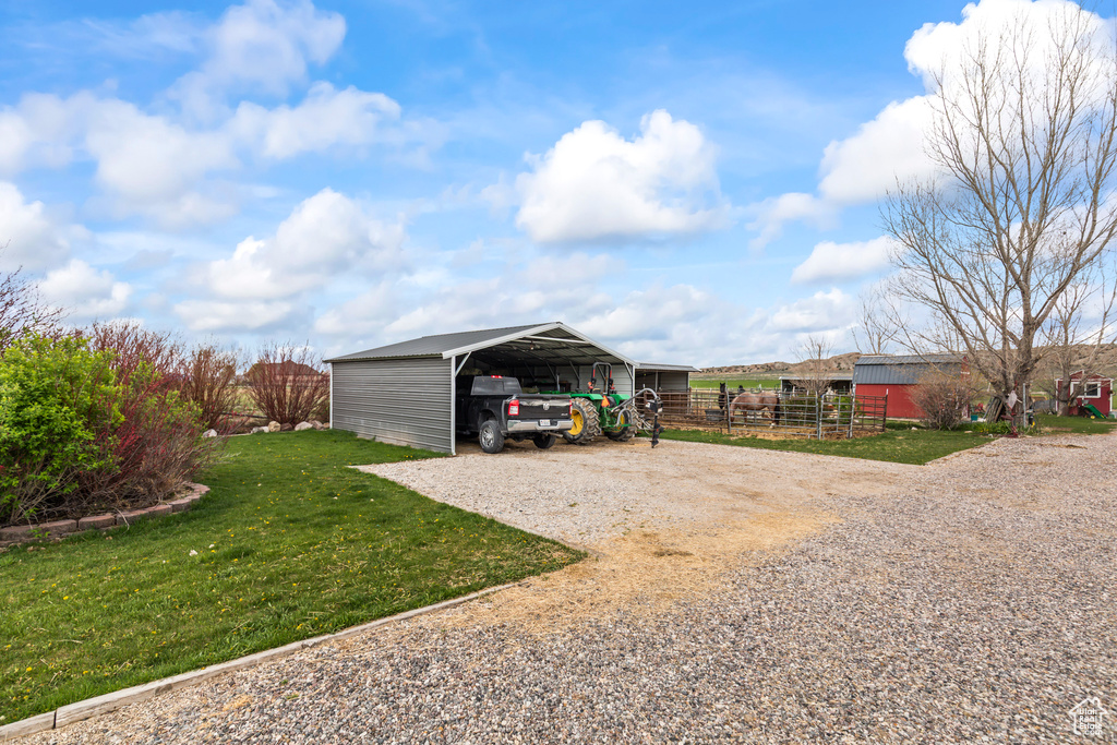 Exterior space featuring fence, gravel driveway, and a carport