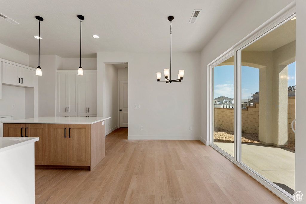 Kitchen featuring visible vents, recessed lighting, light countertops, light wood finished floors, and a notable chandelier