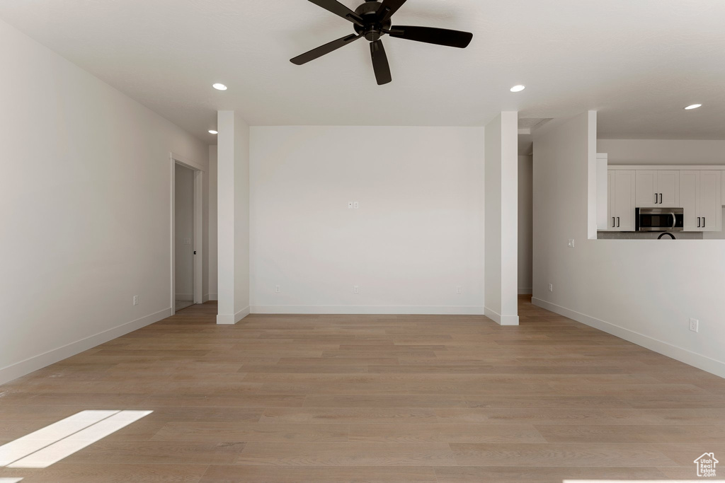 Unfurnished living room with recessed lighting, baseboards, ceiling fan, and light wood-style floors