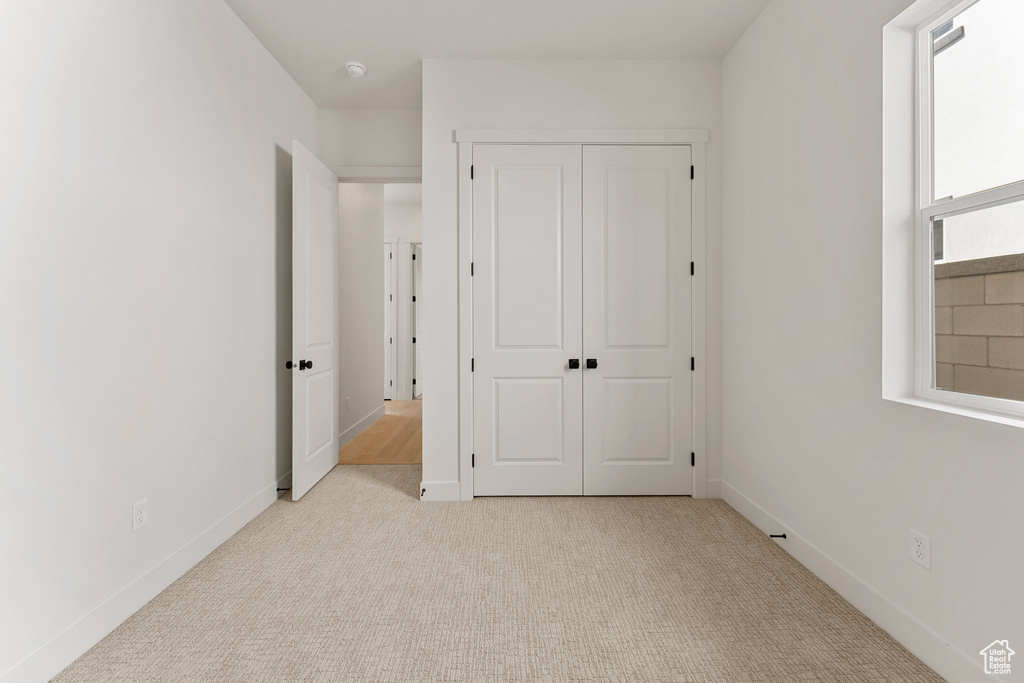 Unfurnished bedroom featuring a closet, carpet flooring, and baseboards