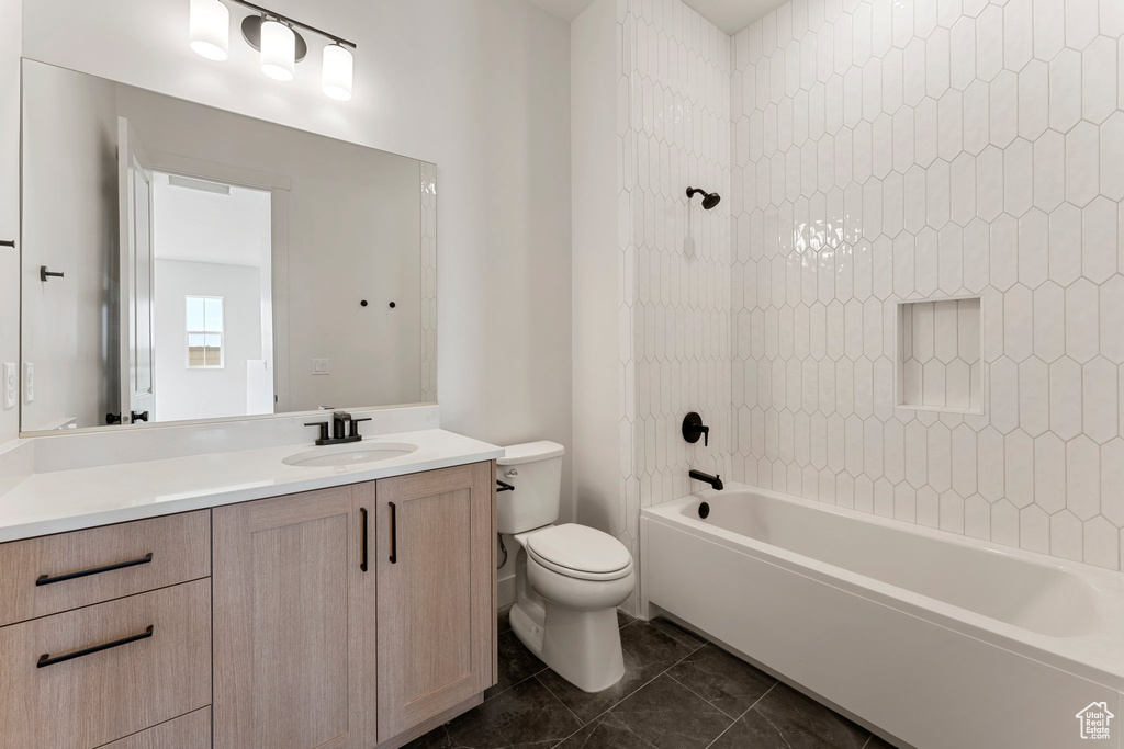 Bathroom with toilet, shower / washtub combination, and vanity