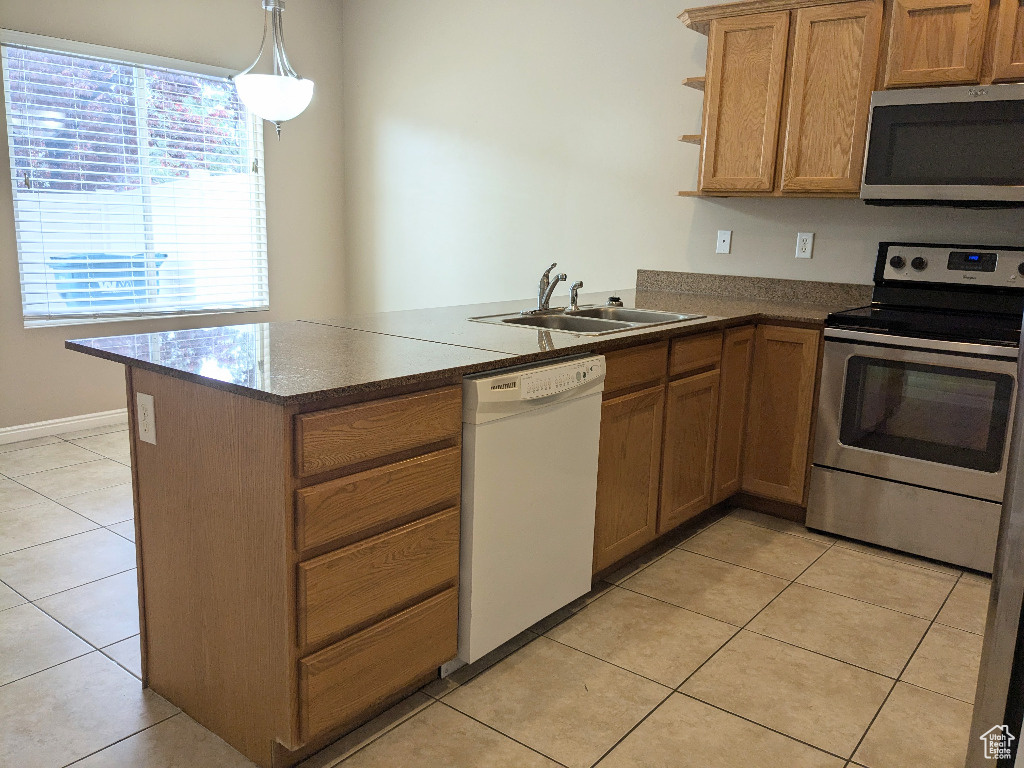 Kitchen featuring a sink, appliances with stainless steel finishes, a peninsula, and a wealth of natural light