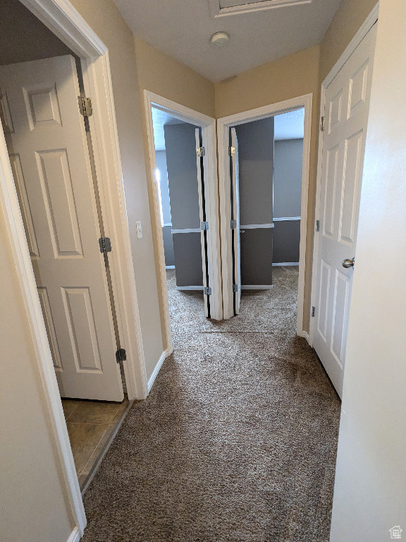 Corridor featuring carpet floors and baseboards