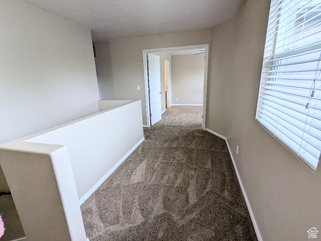 Hall with carpet floors and baseboards