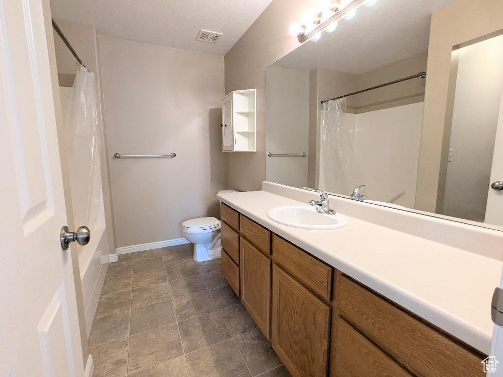 Full bathroom with a shower with curtain, visible vents, vanity, baseboards, and toilet