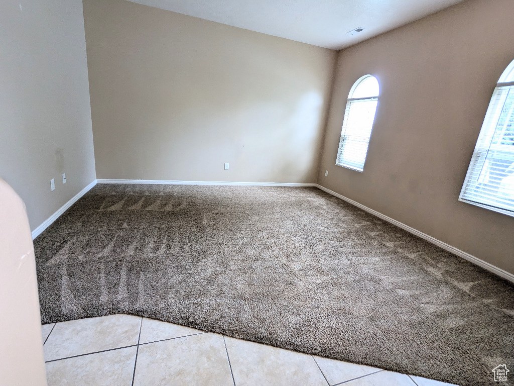 Empty room featuring baseboards, carpet flooring, and visible vents