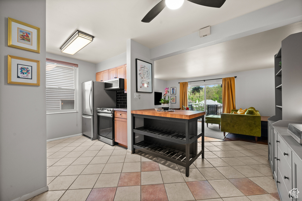 Kitchen featuring ceiling fan, light brown cabinets, stainless steel appliances, baseboards, and light tile patterned floors