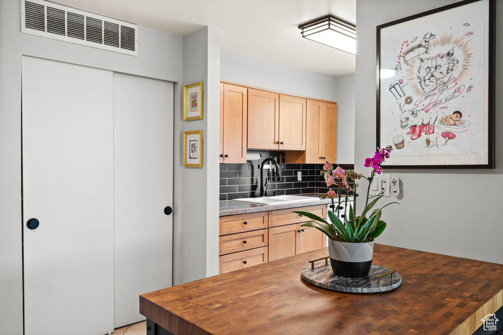 Kitchen featuring a sink, light brown cabinets, butcher block counters, and visible vents