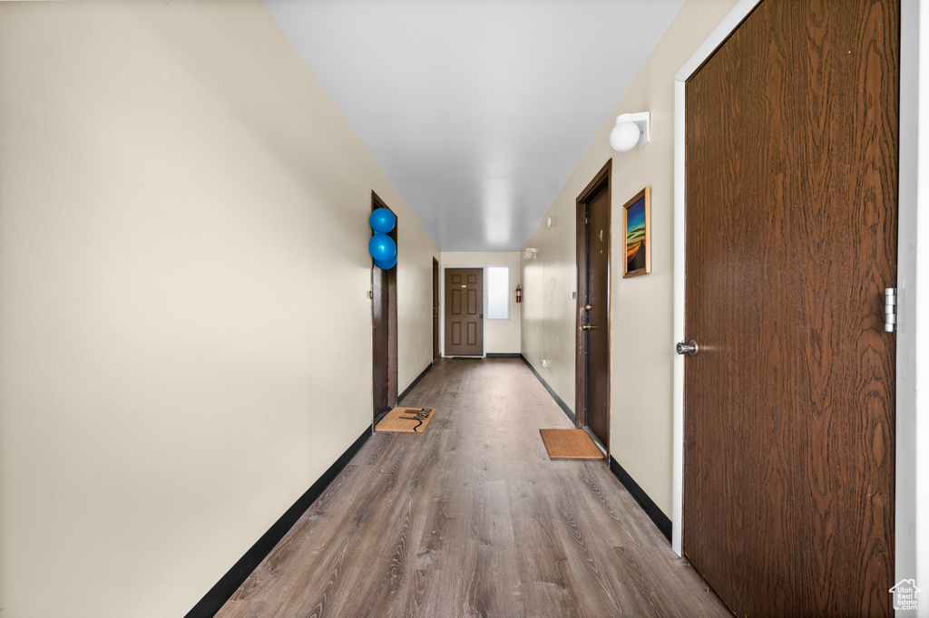 Corridor featuring baseboards and wood finished floors
