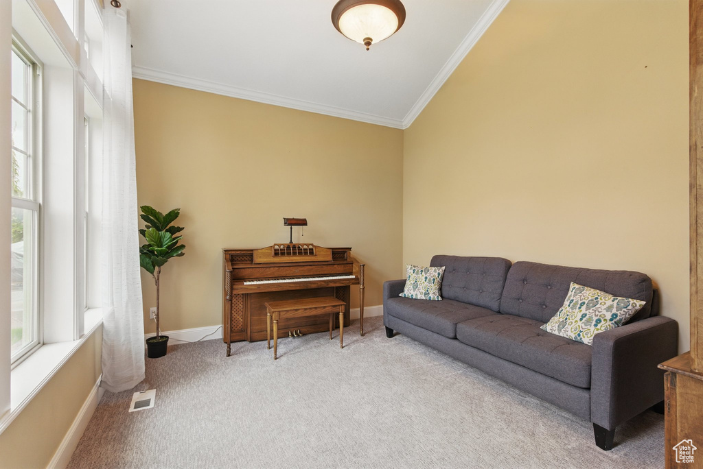 Living room featuring visible vents, crown molding, vaulted ceiling, carpet floors, and baseboards