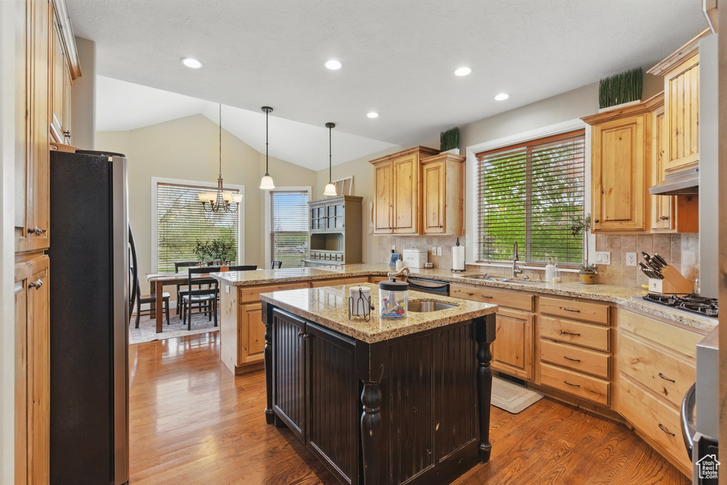 Kitchen with light brown cabinetry, appliances with stainless steel finishes, and a sink