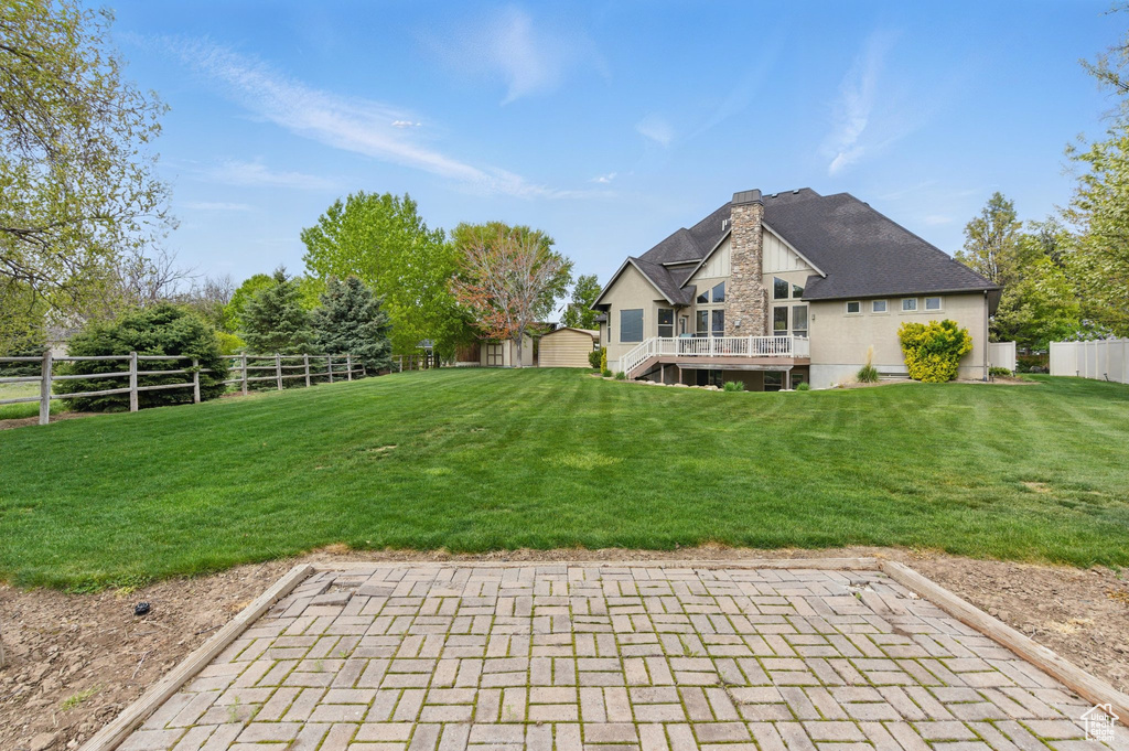View of yard featuring a storage unit, a fenced backyard, an outbuilding, and a deck