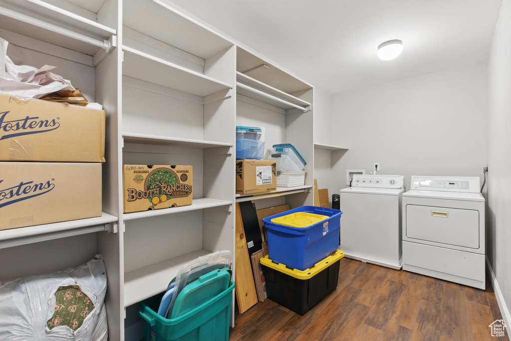 Laundry area with laundry area, dark wood finished floors, and washing machine and dryer