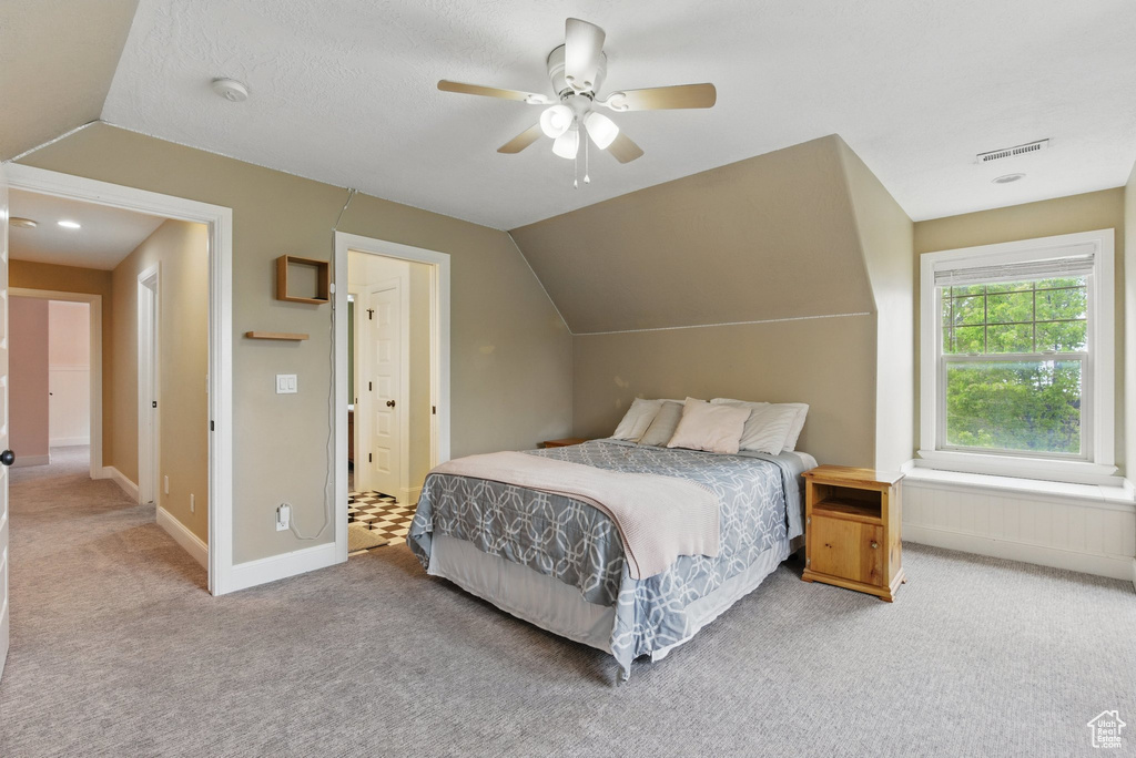 Bedroom featuring carpet floors, a ceiling fan, baseboards, vaulted ceiling, and visible vents