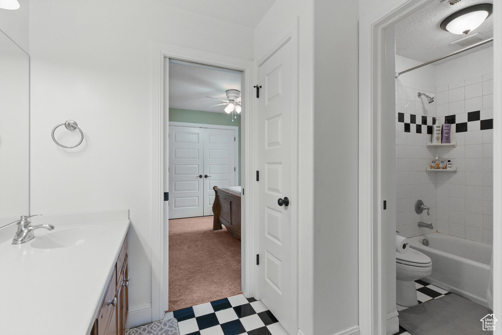 Full bath with vanity, toilet, shower / bathing tub combination, tile patterned floors, and a ceiling fan