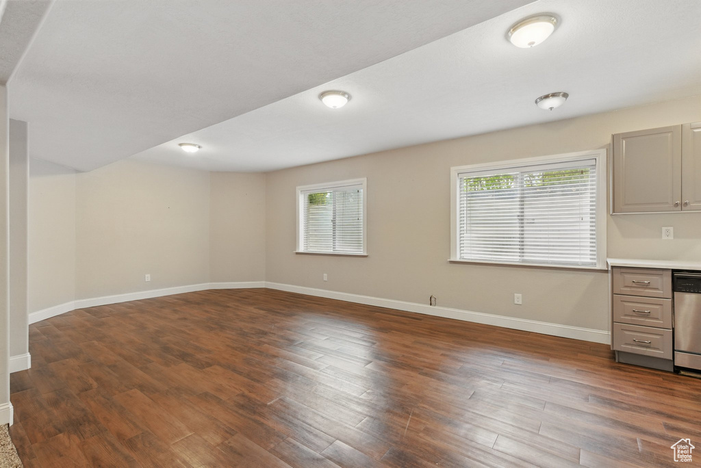 Interior space with baseboards and dark wood-style flooring