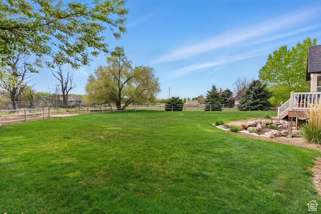 View of yard with fence and a deck